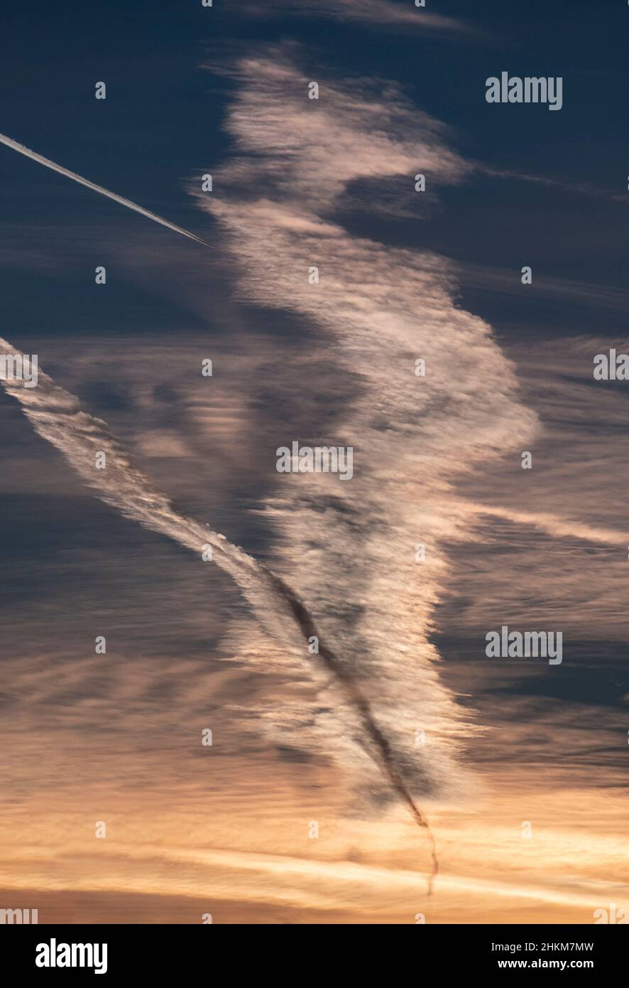 Ein Kreuzungsmuster aus Dampfspuren, das von hoch fliegenden Flugzeugen an einem kalten Morgen verursacht wird, schmückt den Himmel über Worcestershire, England. Stockfoto