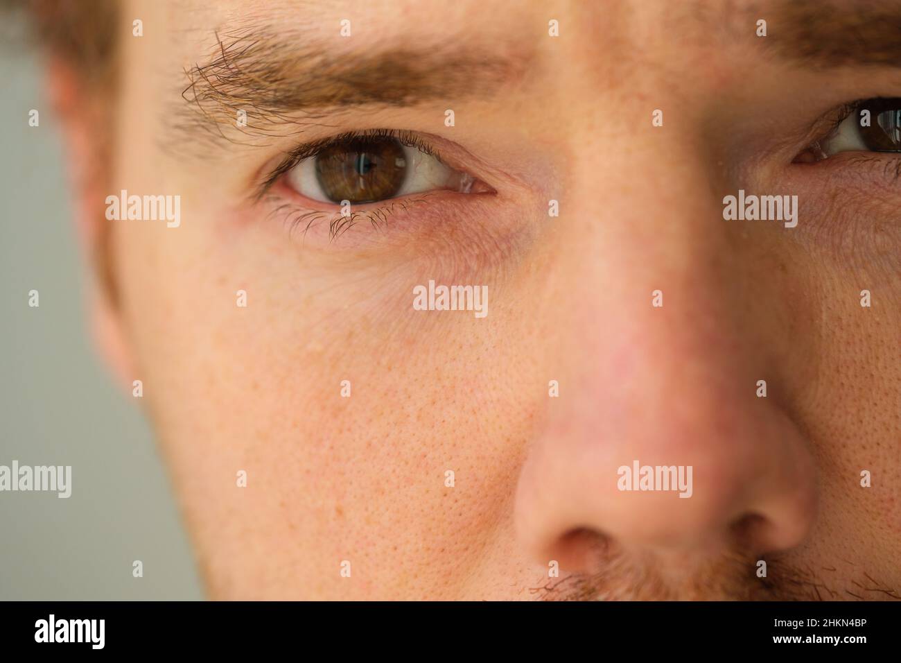 Makroaufnahme eines gutaussehenden blonden Mannes mit braunen Augen, Nahaufnahme des Gesichts und des Auges eines gutaussehenden Mannes. Stockfoto