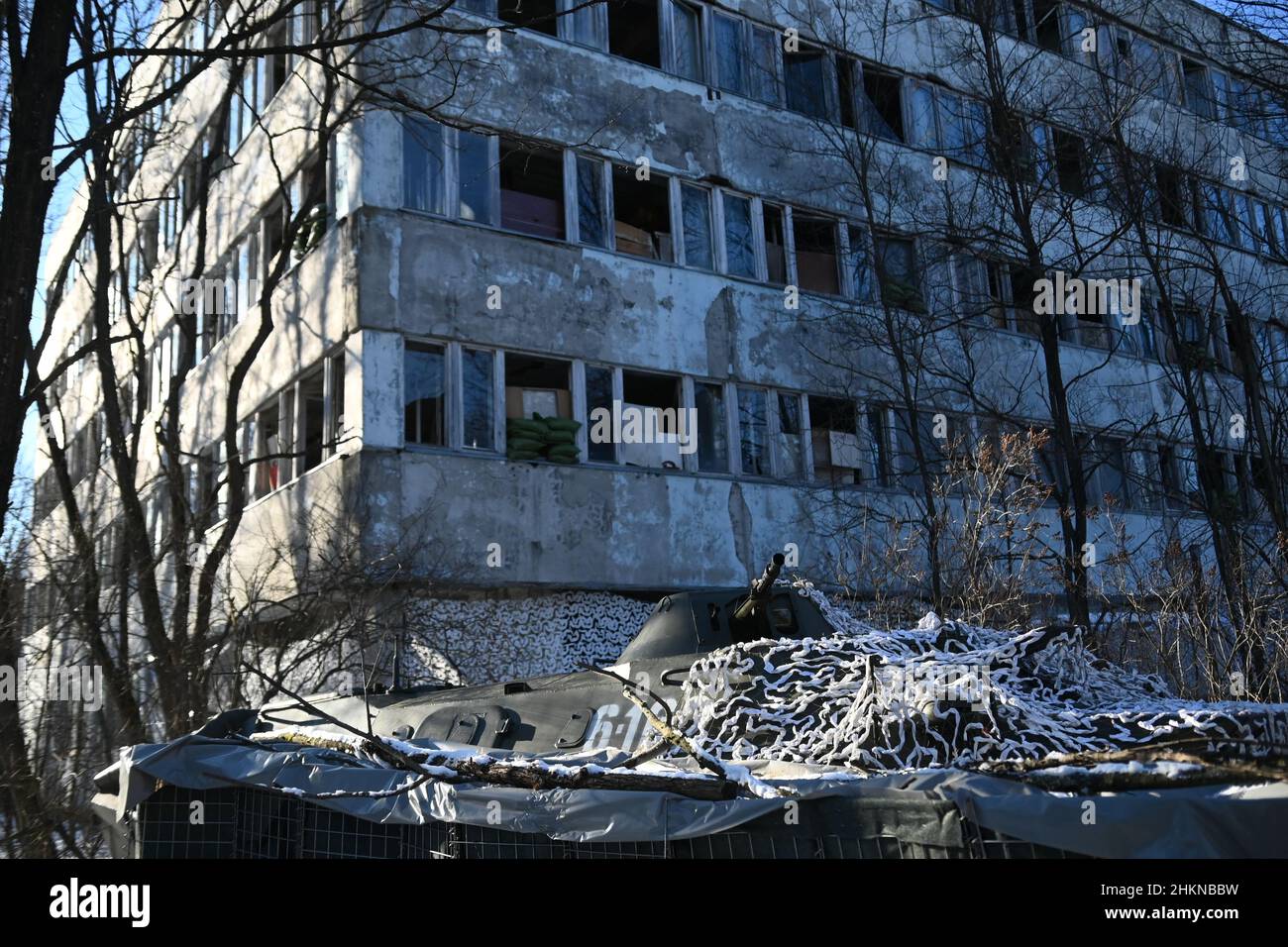 Pripjat, Ukraine. 04th. Februar 2022. Während einer städtischen Kriegsführung, die das ukrainische Innenministerium im Dorf Pripjat in der Nähe der weißrussischen Grenze durchgeführt hat, während die russischen Streitkräfte am 4. Februar weiterhin an den Grenzen des Landes mobilisieren, sitzt hinter der Abdeckung ein Panzerwagen BTR-80 vor einem befestigten Gebäude. 2022 in Pripyat, Ukraine. (Foto von Justin Yau/Sipa USA) Quelle: SIPA USA/Alamy Live News Quelle: SIPA USA/Alamy Live News Stockfoto