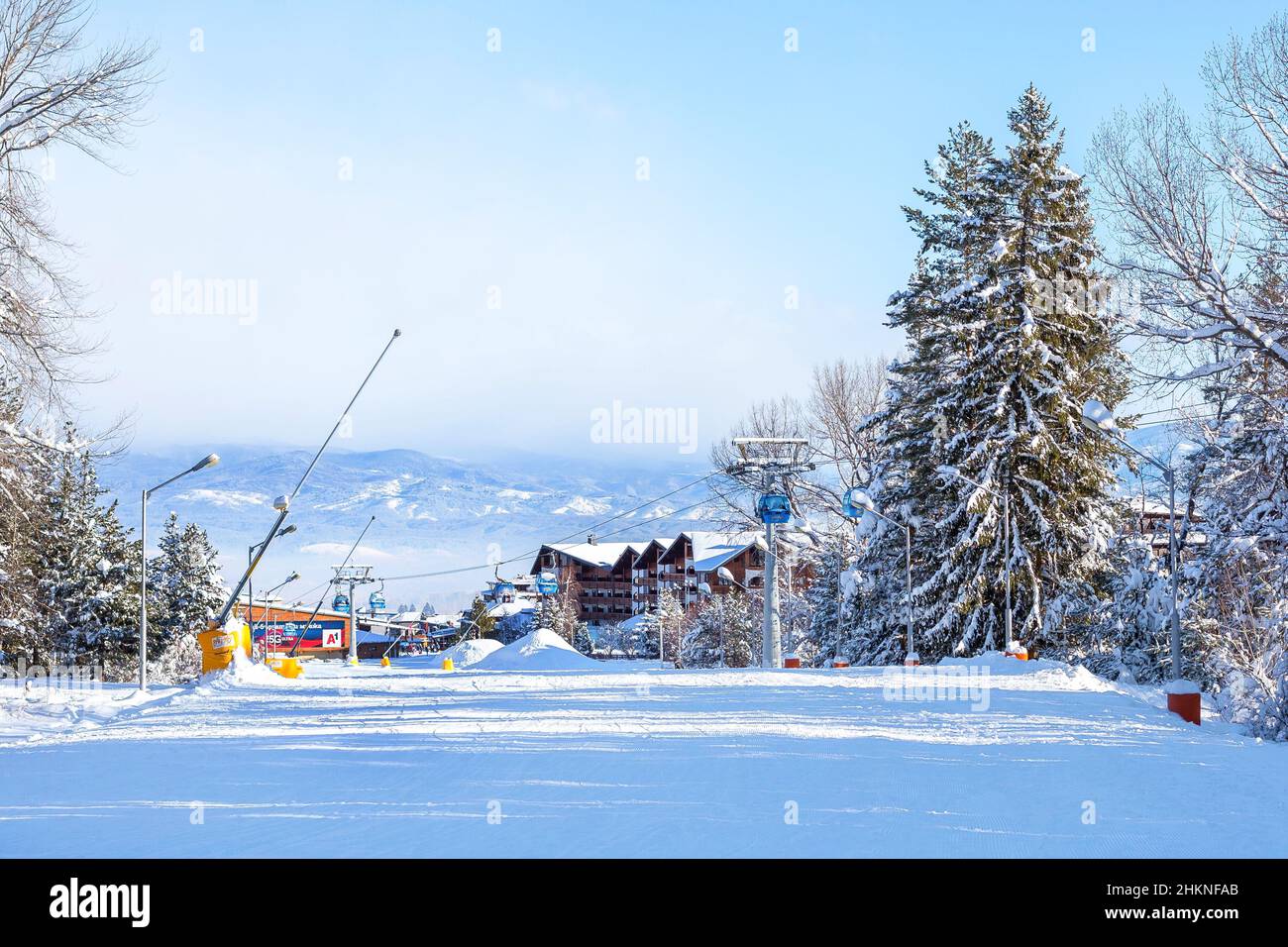 Bansko, Bulgarien - 3. Februar 2022: Bulgarisches Winter-Skigebiet mit Skipiste, Lifthütten und Gondelstation Stockfoto