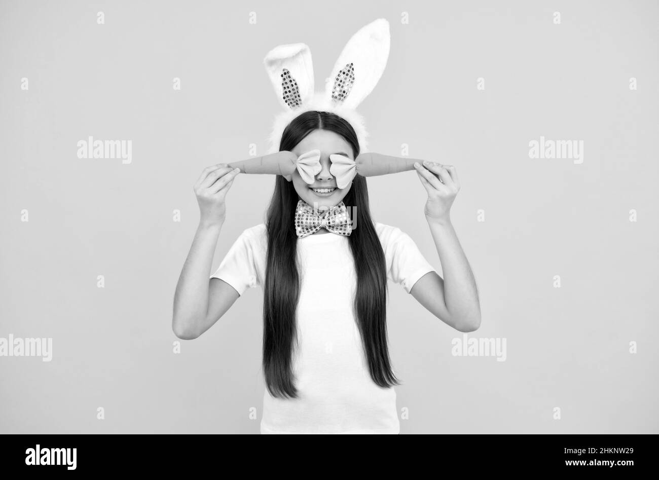 Frohe ostern Kind Mädchen in Hasenohren und Fliege halten Karotte, frohe ostern Stockfoto