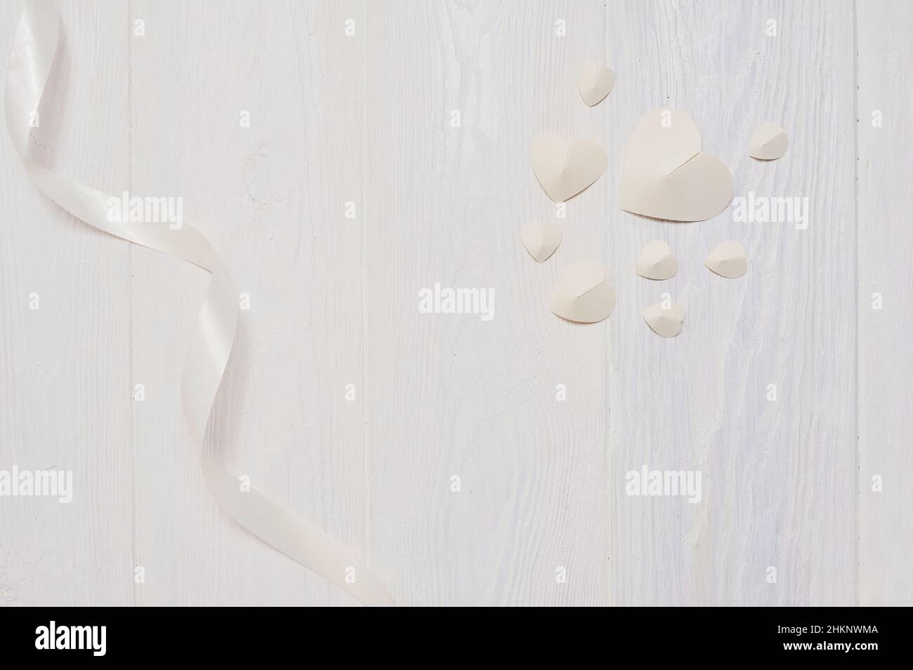 Mockup für Valentinstag Grußkarte. Weißes Papier Herzen und Band Flatlay auf einem weißen Holzhintergrund mit Platz für Ihre Liebe Text. Flach liegend Stockfoto