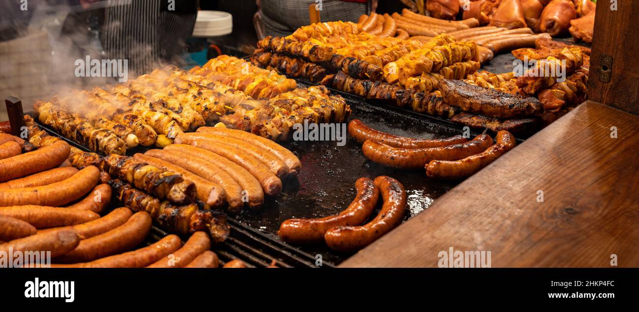 Viel leckeres saftiges Fleisch, bbq, Grill im Freien, Würstchen, Shahlik, Dampfgaren über heißen Grillspeisen, hohe Auflösung, Weitwinkel, Panorama, warme Farben. Tra Stockfoto