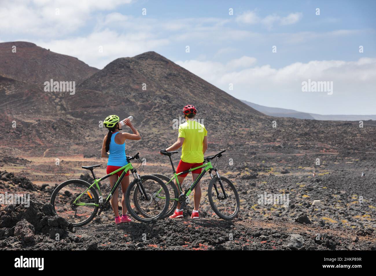 Biken Abenteuer MTB Fahrräder Radfahrer Radfahren auf extreme Lava vulkanischen Landschaft. Zwei Biker in geführter Gruppentour im Sommerurlaub in Stockfoto