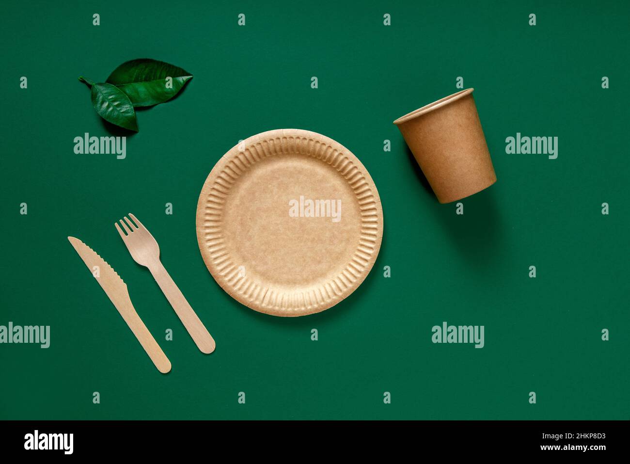 Umweltfreundliches Einweggeschirr für Lebensmittel mit Gabeln, Messern und  Tellern auf grünem Hintergrund. Draufsicht Stockfotografie - Alamy