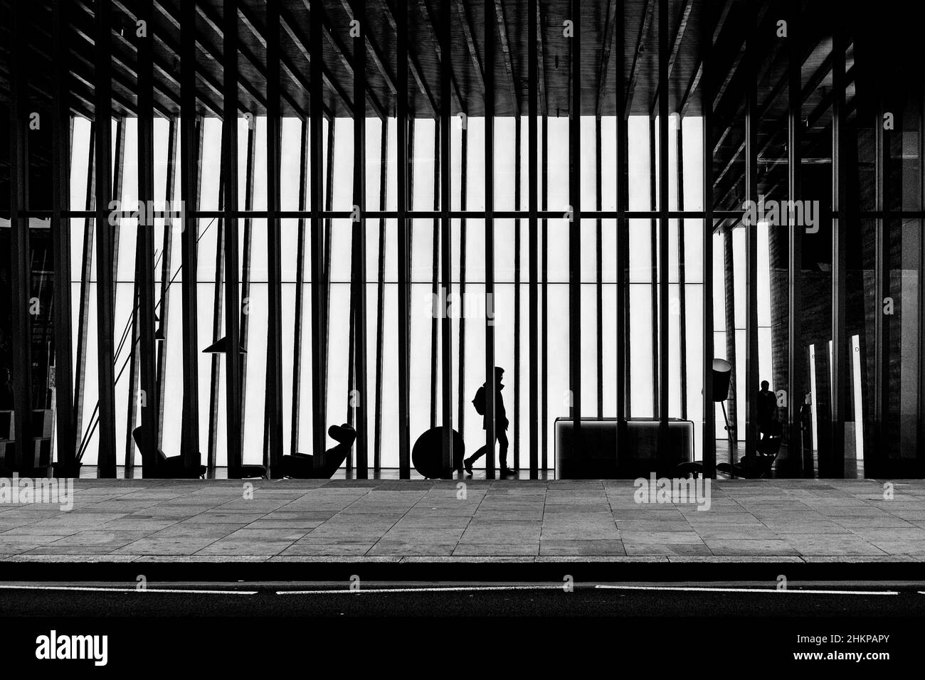London Schwarz-Weiß-Stadtfotografie: Silhouettenfigur im Foyer eines modernen Gebäudes. London, Großbritannien Stockfoto
