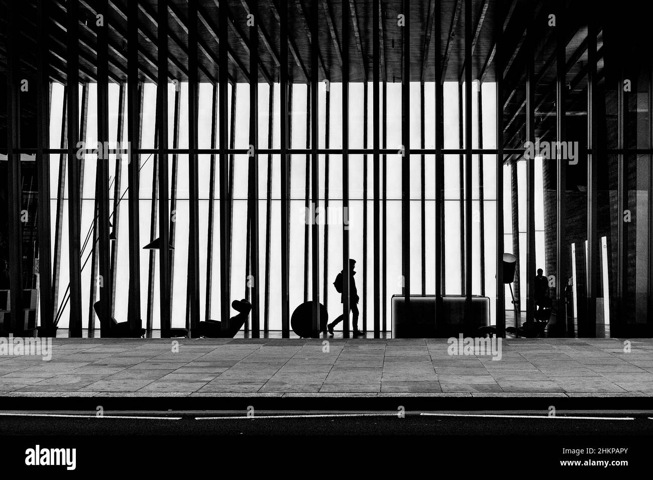 Londoner Schwarzweißfotografie: Silhouettenfigur im Foyer eines modernen Bürogebäudes. City of London, Großbritannien Stockfoto