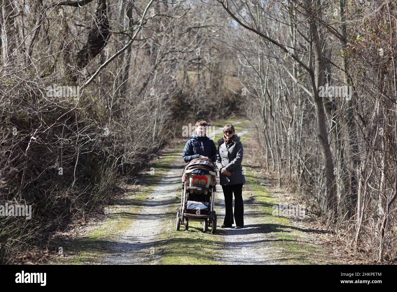 Zwei Frauen laufen mit einem Perambulator im Park Stockfoto