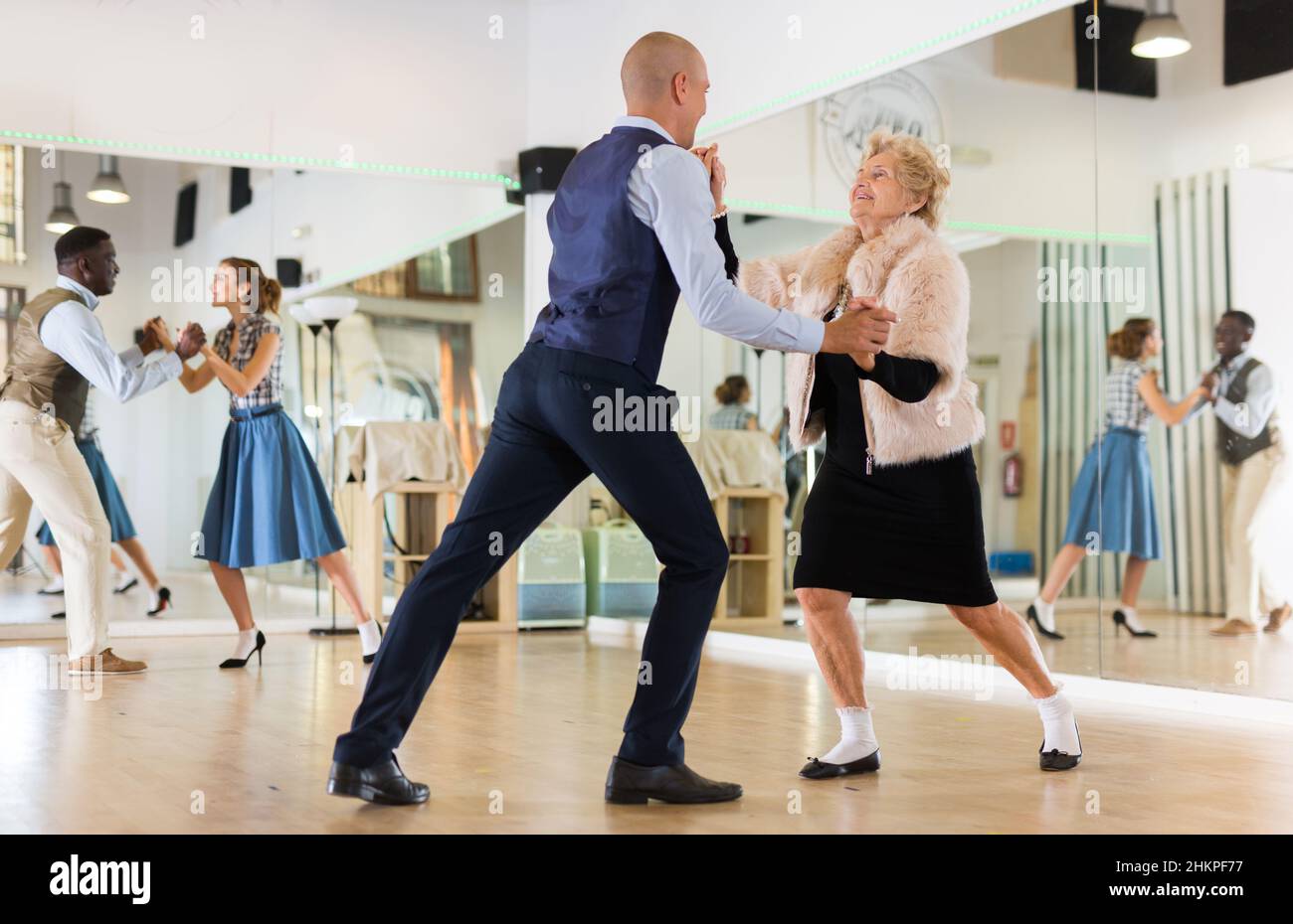 Reife Frau tanzt Schaukel mit jungen Mann Stockfoto