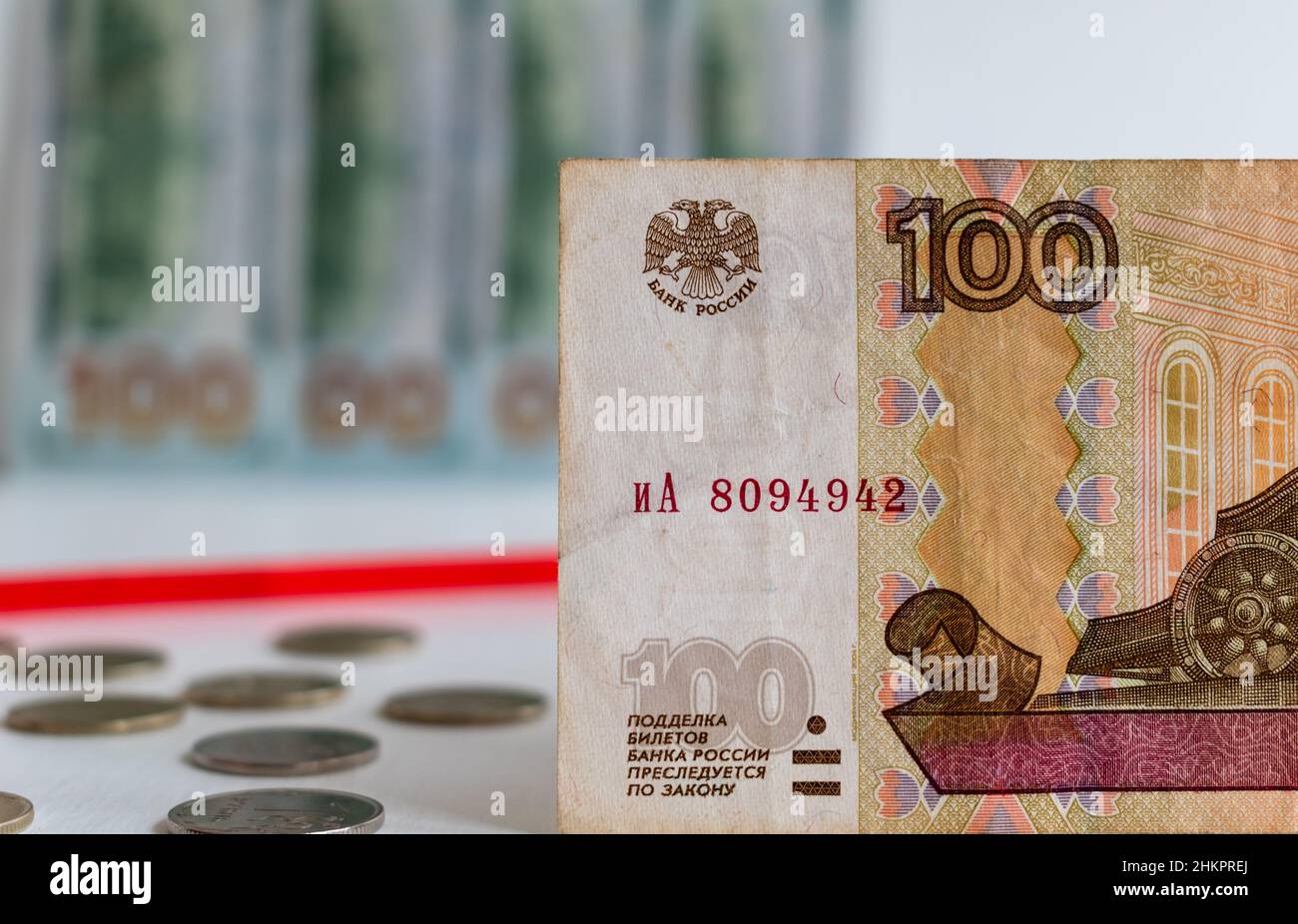 Eine Nahaufnahme der Banknote aus hundert russischen Rubel auf einem verschwommenen Hintergrund aus roter Linie und US-Dollar Stockfoto
