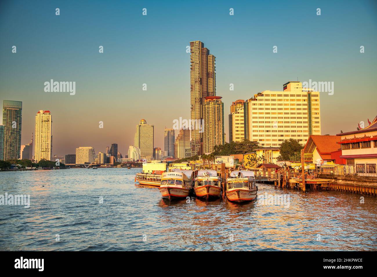 Bangkok, Thailand - 5. Januar 2020: Chao Phraya River und Wolkenkratzer von der Asiatique Waterfront bei Sonnenuntergang Stockfoto