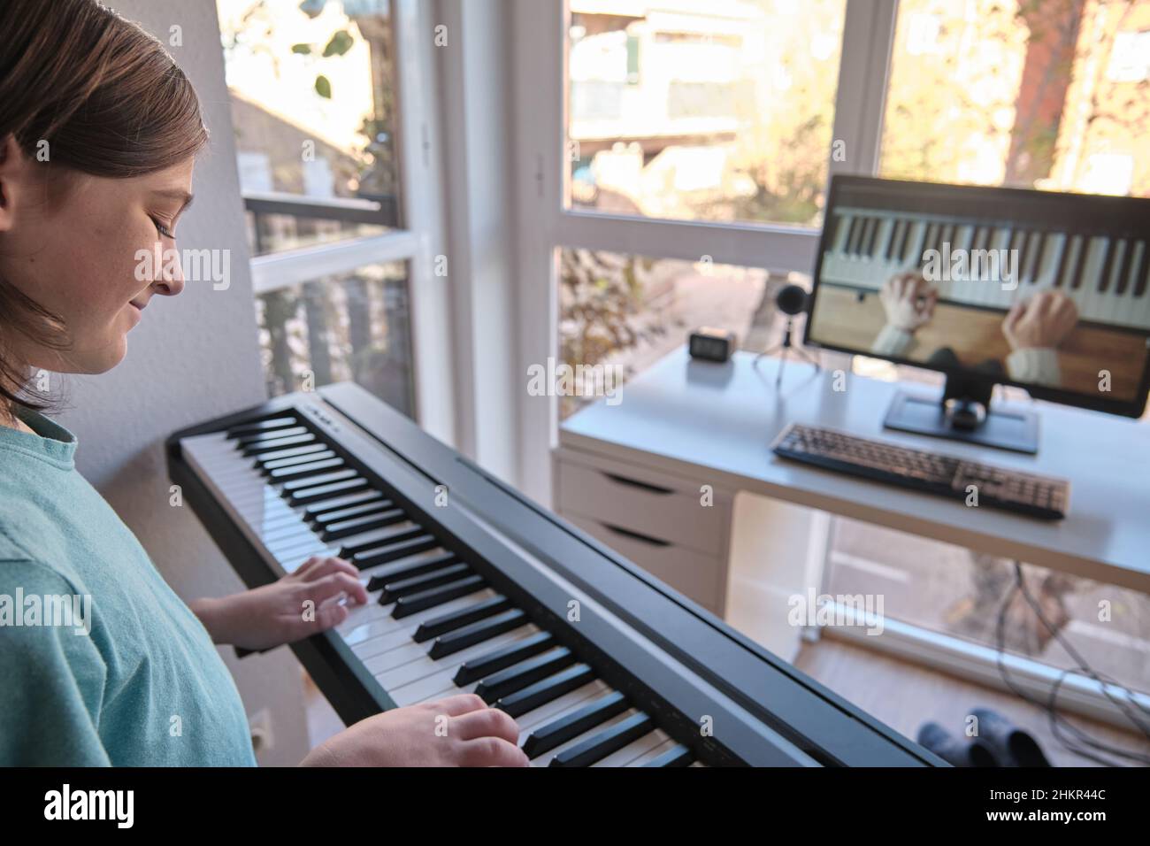 Homeschool europäischen jungen Klavier lernen vom Computer Verbindung zu Internet-Musik Online-Klasse von der Lehrerin. Neuer normaler Lebensstil. Stockfoto