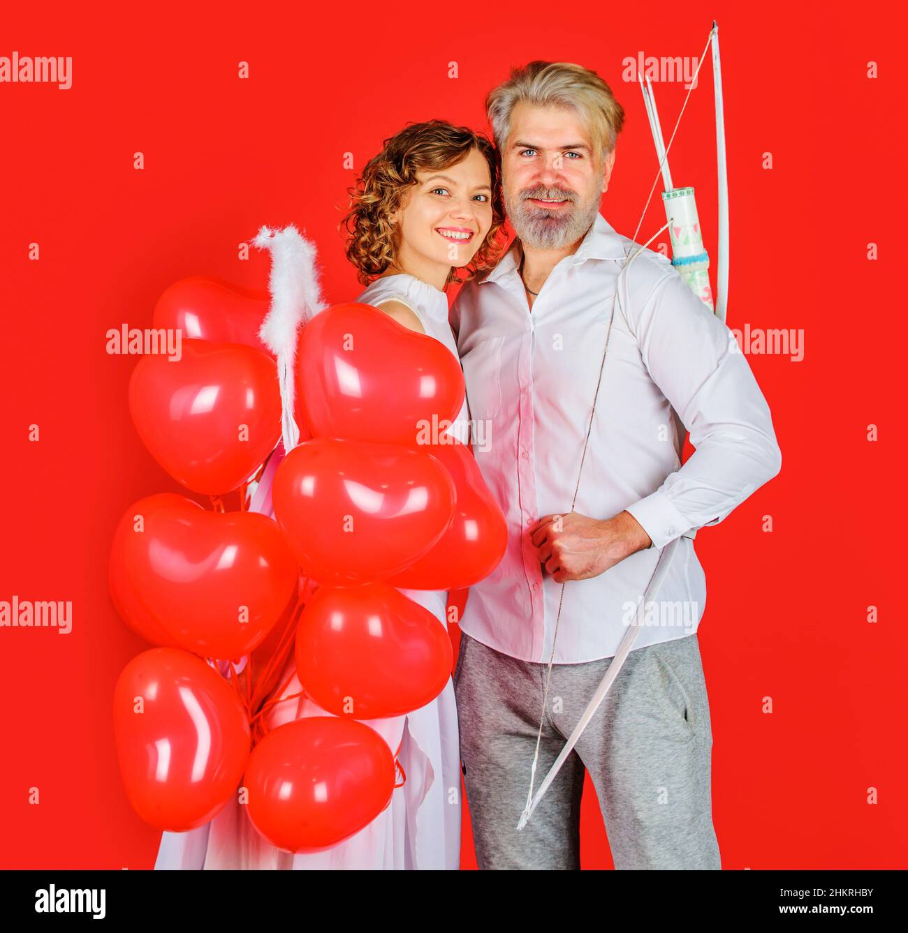 Paar am Valentinstag. Engel mit herzförmigen Ballons. Amor mit Bogen und Pfeilen. Beziehungen. Stockfoto