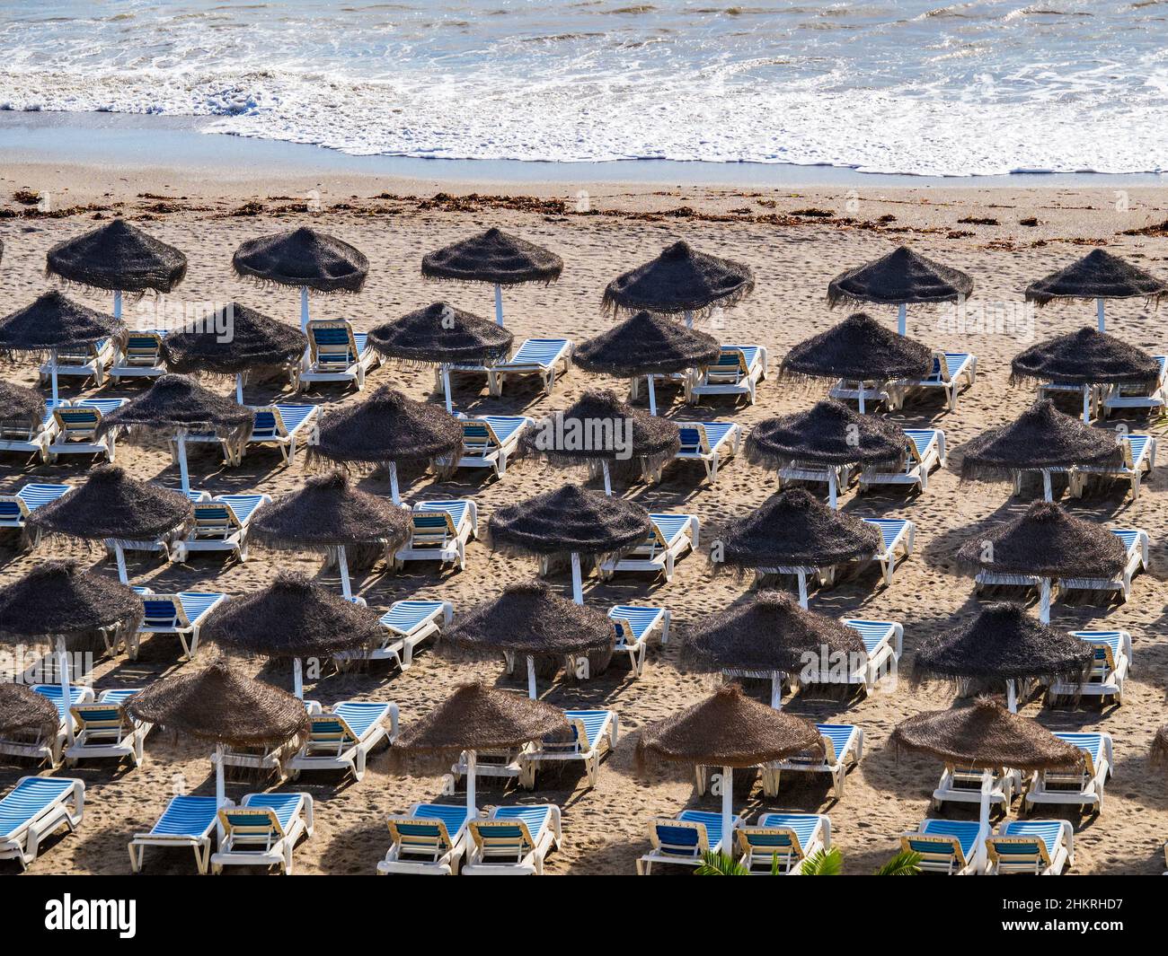 Sonnenschirme und Liegestühle vor dem Meer in Málaga Stockfoto