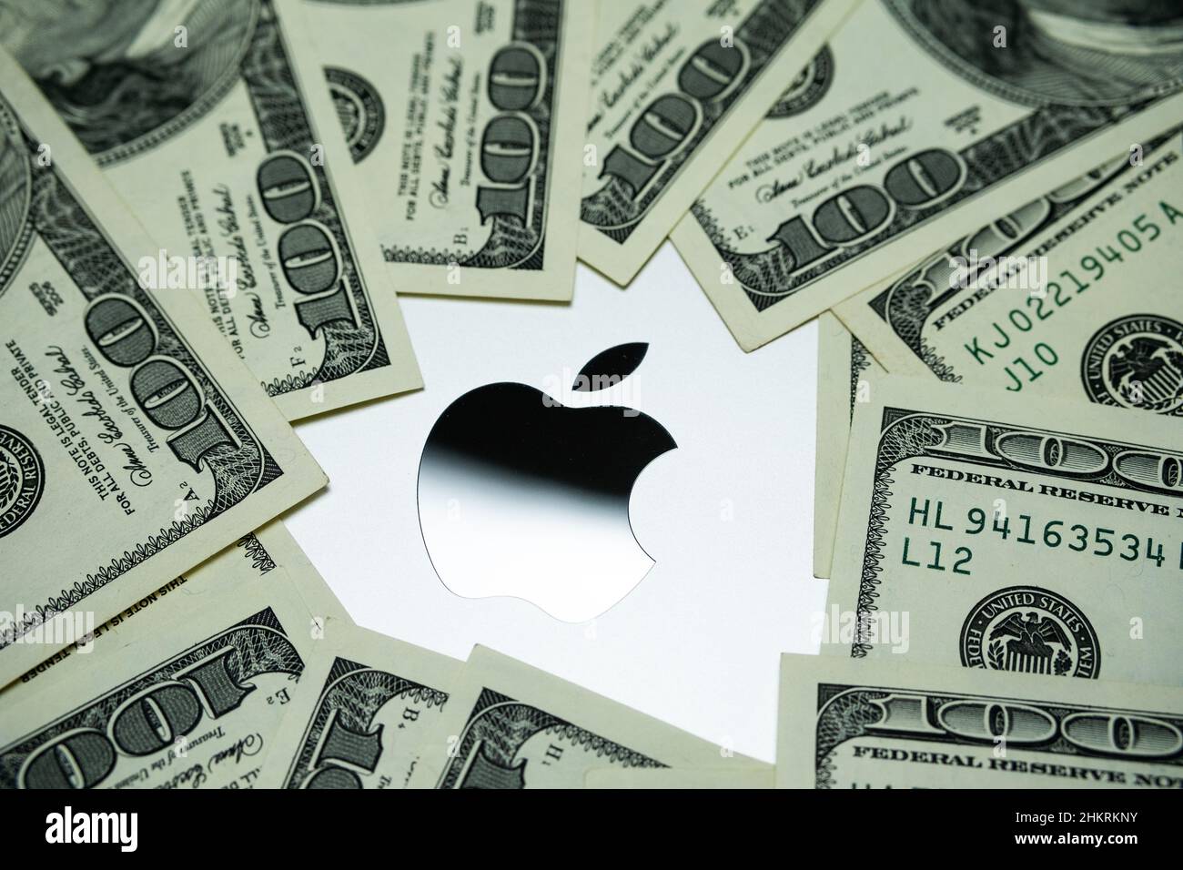 Apple-Firmenlogo auf dem Laptop Macbook M1, umgeben von US-Dollar-Banknoten. Konzept. Selektiver Fokus. Großbritannien, Stafford, 18. Dezember 2021. Stockfoto