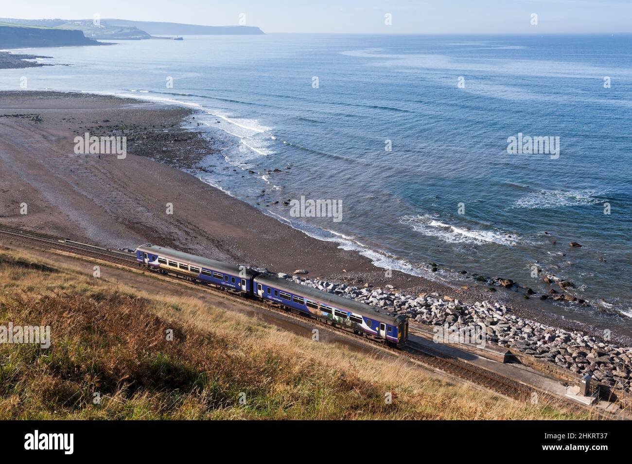 Der Sprinter der Nordbahn der Klasse 156 fährt auf der malerischen Bahnlinie Cumbrian Coast, Cumbria, Großbritannien, entlang des Meeres an der Küste Stockfoto