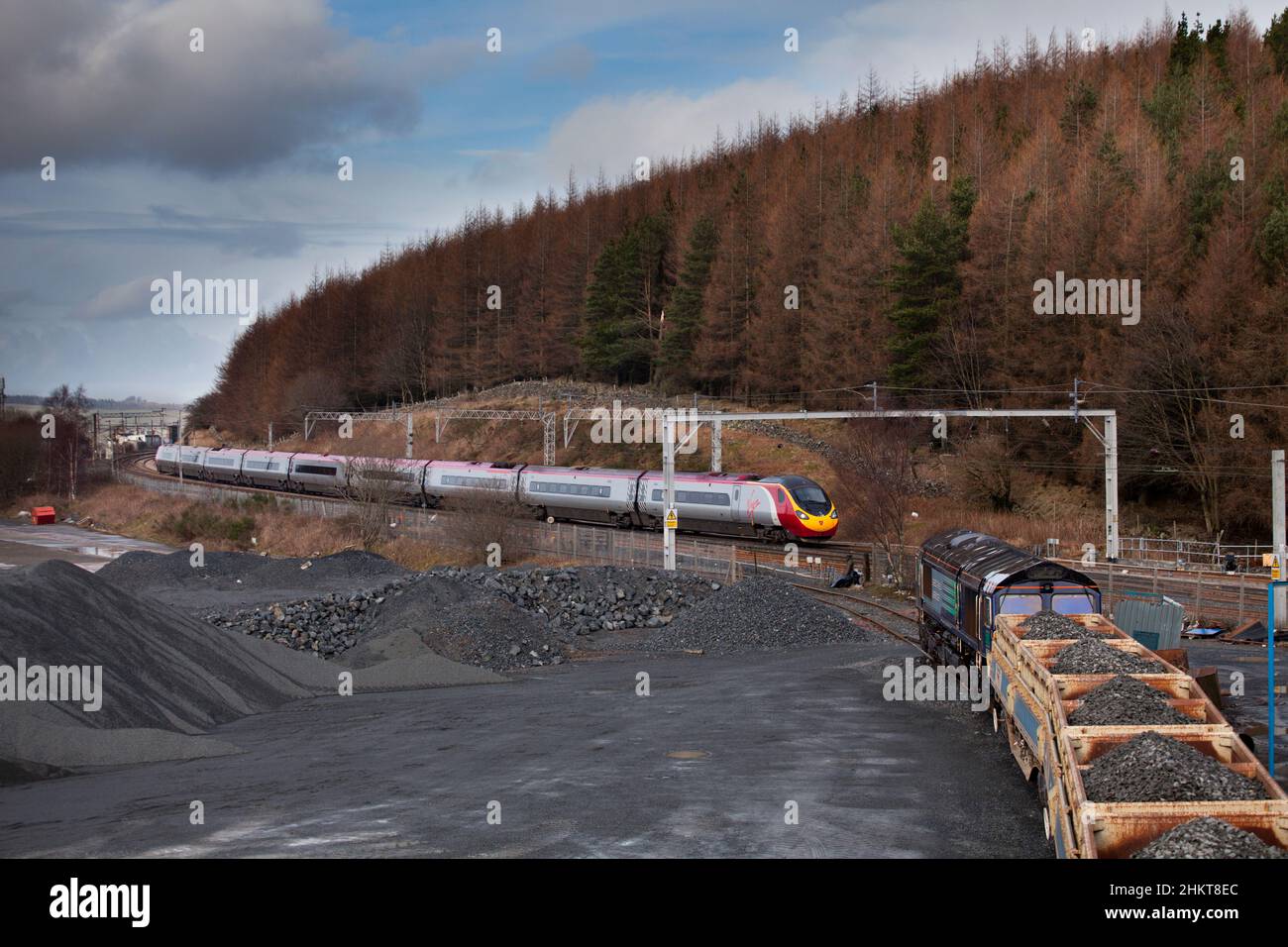 Güter- und Personenzüge, die am Shap Summit (Cumbria) an der Hauptlinie der Westküste vorbeifahren, wartet die DRS-Klasse 66 auf die Abfahrt vom blauen Schap-Steinbruch Stockfoto