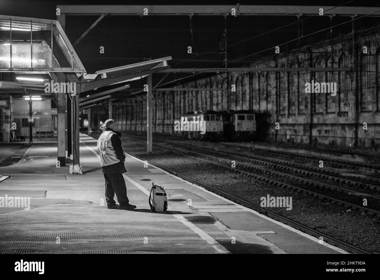 Freightliner-Zugfahrer wartet am Bahnhof Carlisle, um von einem Güterzug abgeholt zu werden, um ihn zurück nach Norden zu bringen Stockfoto