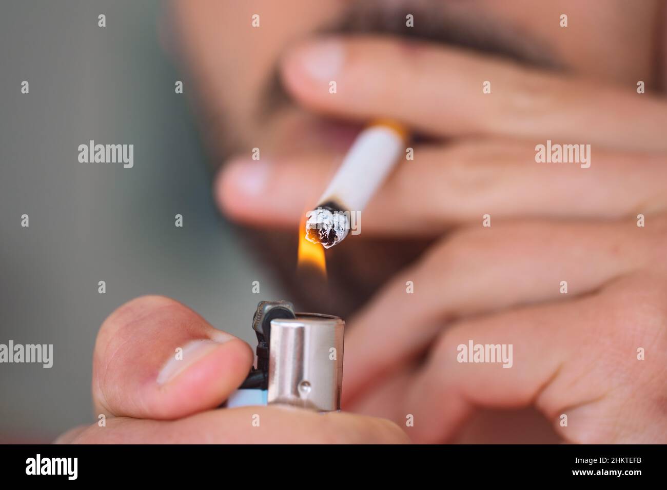 Nahaufnahme eines jungen Mannes, der Zigarette anzündet und raucht. Rauchen sucht und schlechte Gewohnheit Konzept Stockfoto
