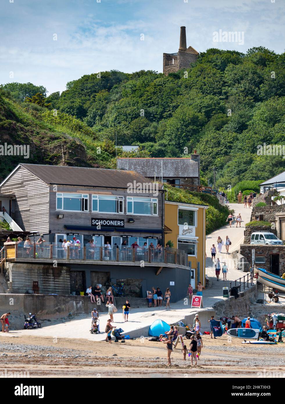 St.Agnes, Cornwall, England, Großbritannien-Juli 22: Das Relikt einer stillschweigendem Zinnmine überblickt die jetzt für Familien genutzte Bucht von Trevaunance Cove während eines heißen Hochsommers Stockfoto