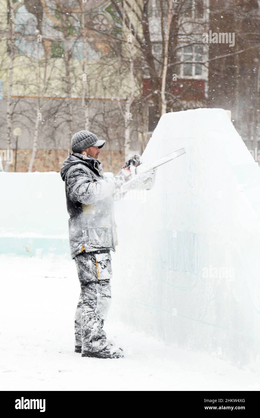 Der Bildhauer Schnitte eis Konturen aus Eis mit einer Kettensäge für Weihnachten Stockfoto