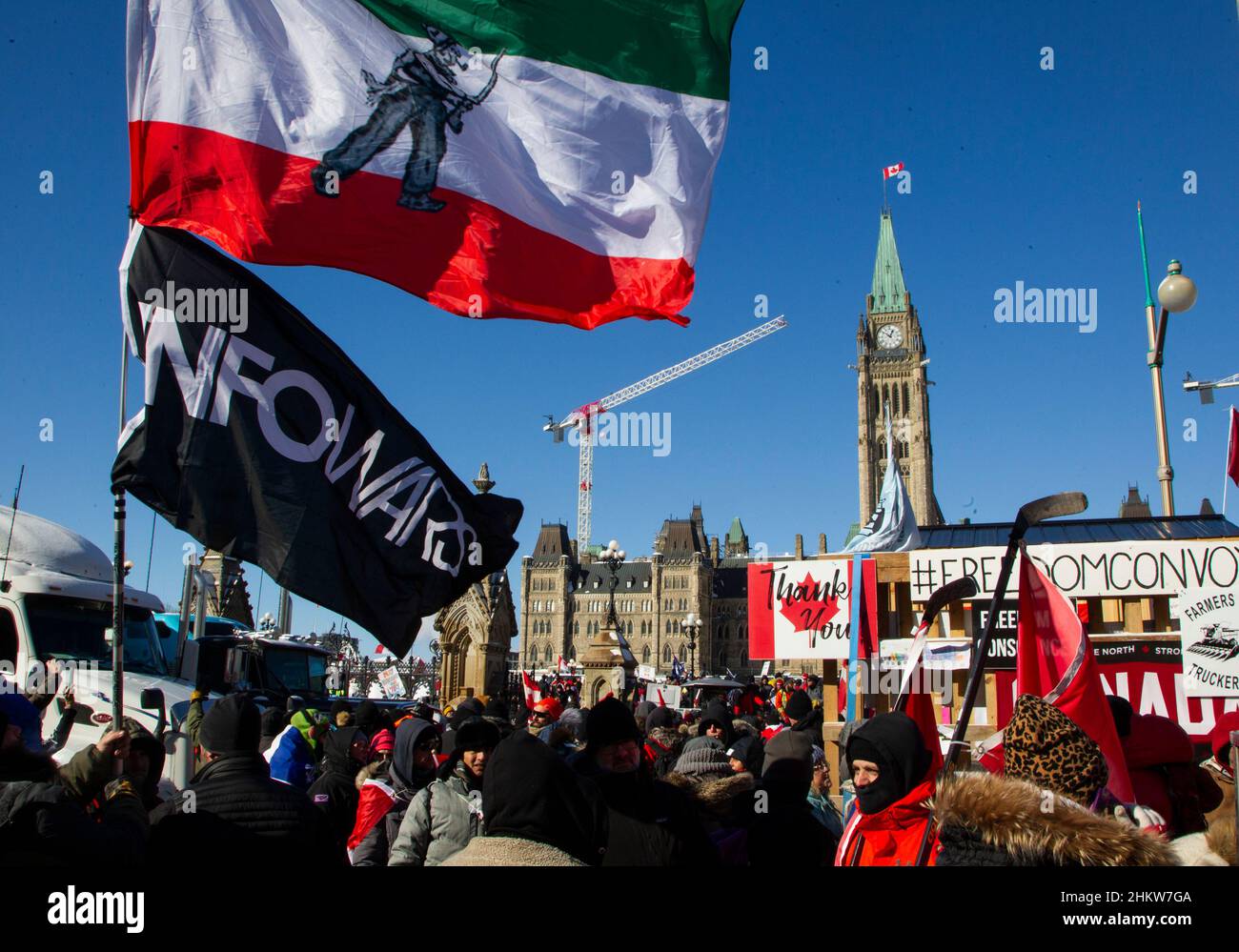 Demonstranten halten vor dem Parlament Flaggen bei der Besetzung der Innenstadt von Ottawa durch den Konvoi 2022, um gegen die Anti-Covid-Maßnahmen der Regierung zu protestieren. Stockfoto