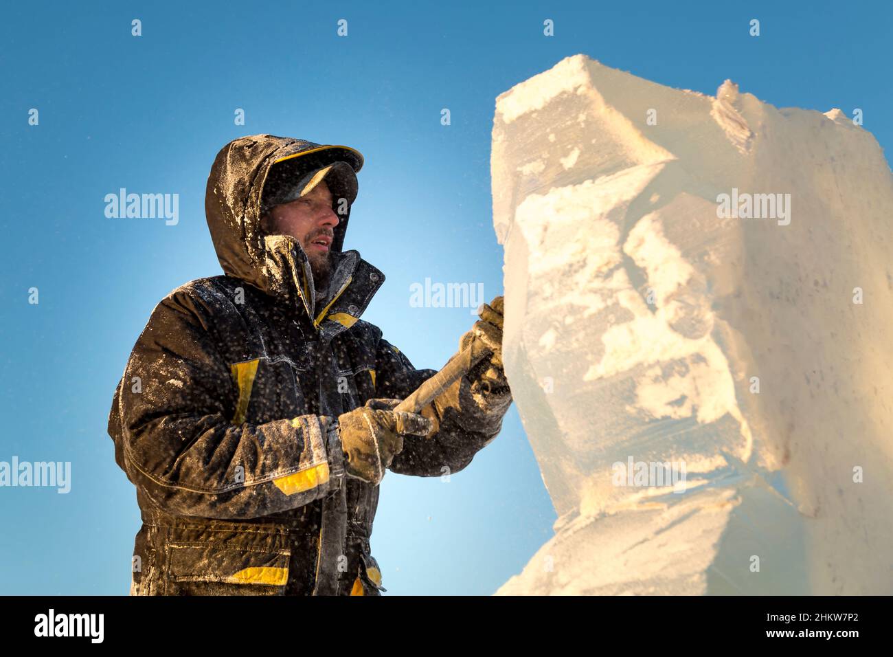 Der Bildhauer schneidet ein Eis Abbildung aus einem Eisblock mit einem Meißel Stockfoto