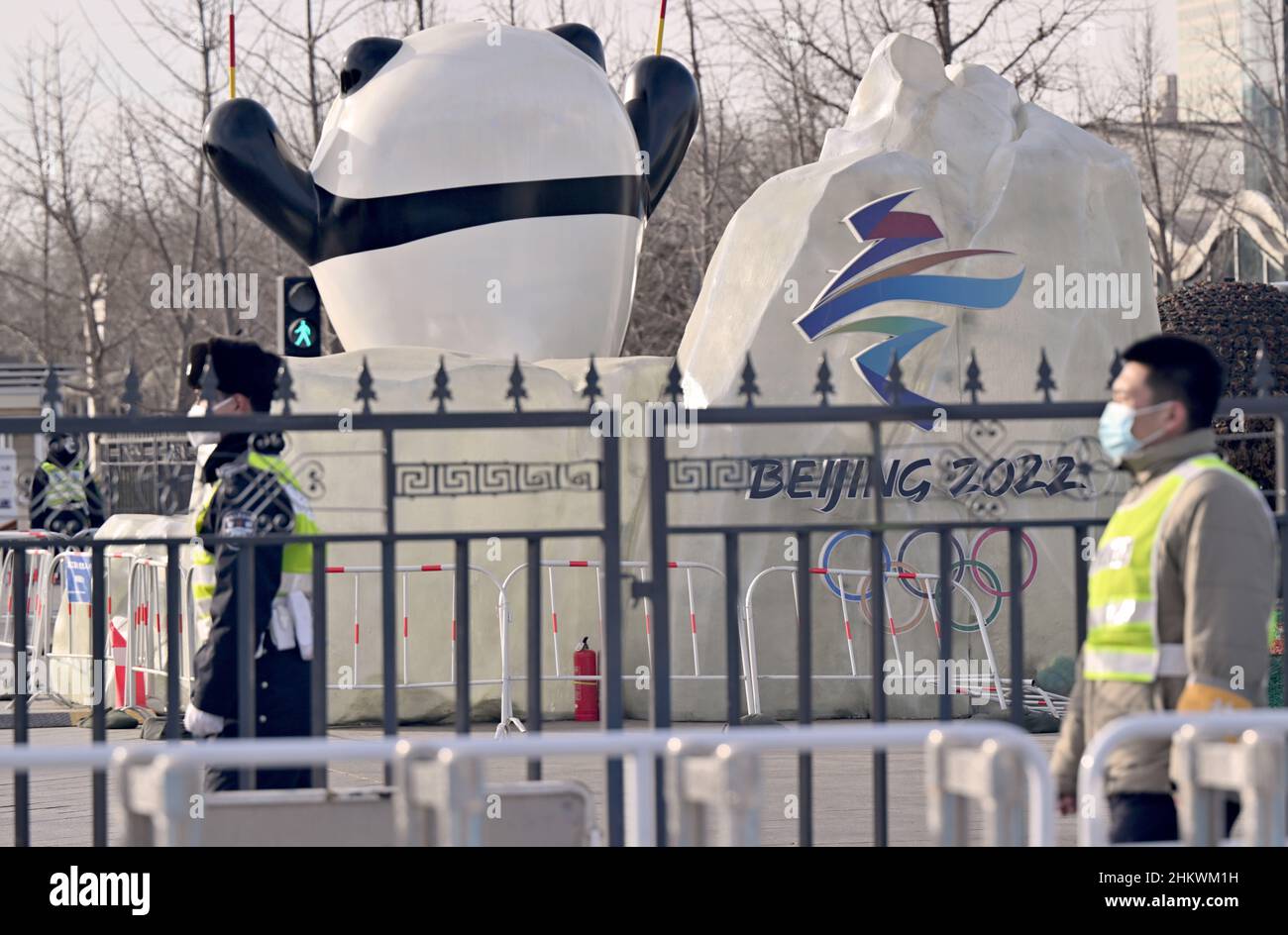 Peking, China. 06th. Februar 2022. Olympische Spiele, Feature. Ein Polizist steht hinter Barrieren beim olympischen Maskottchen Panda Bing Dwen. Kredit: Peter Kneffel/dpa/Alamy Live Nachrichten Stockfoto