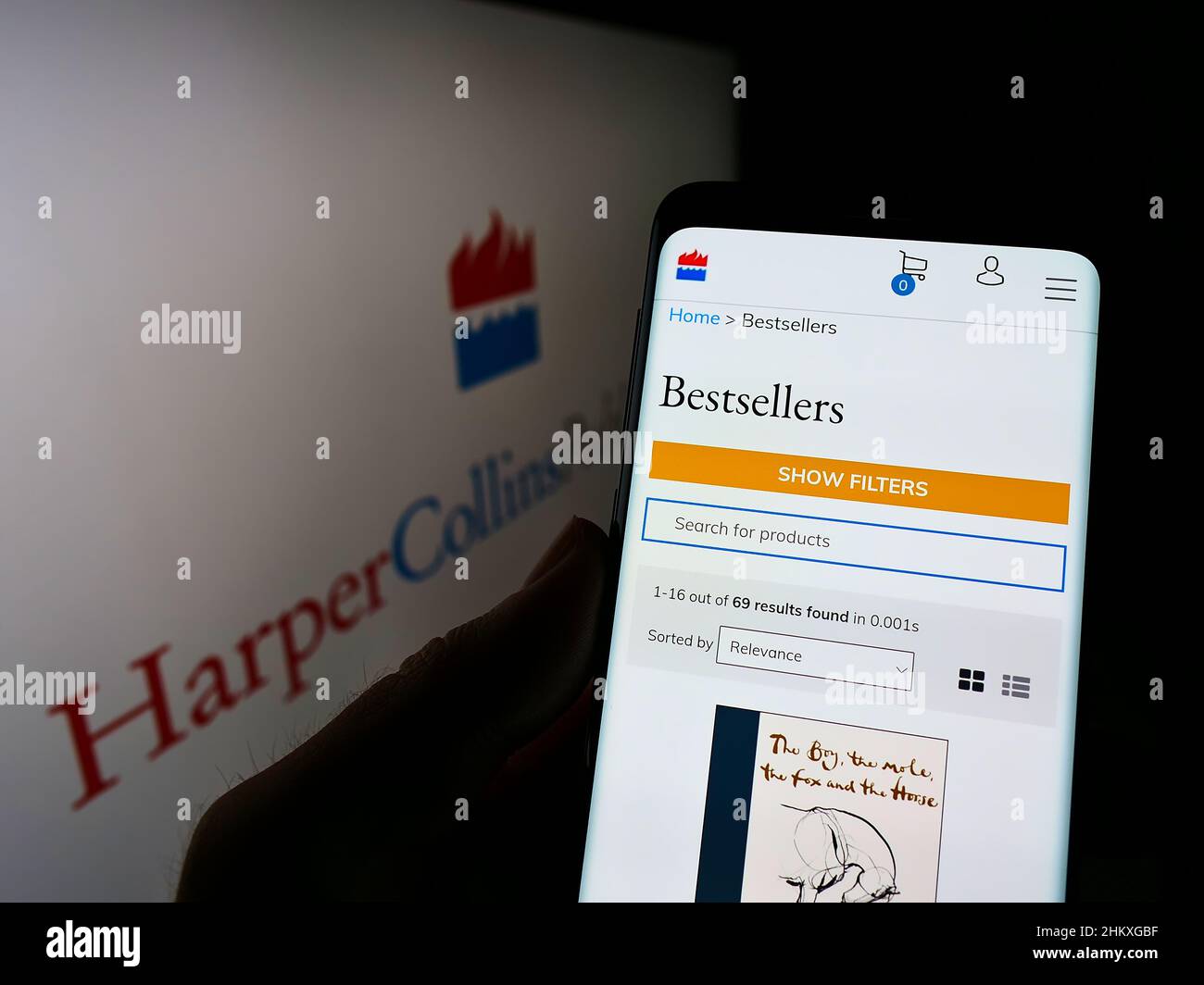 Person, die Smartphone mit Website der US-Firma HarperCollins Publishers LLC auf dem Bildschirm vor dem Logo hält. Konzentrieren Sie sich auf die Mitte des Telefondisplays. Stockfoto