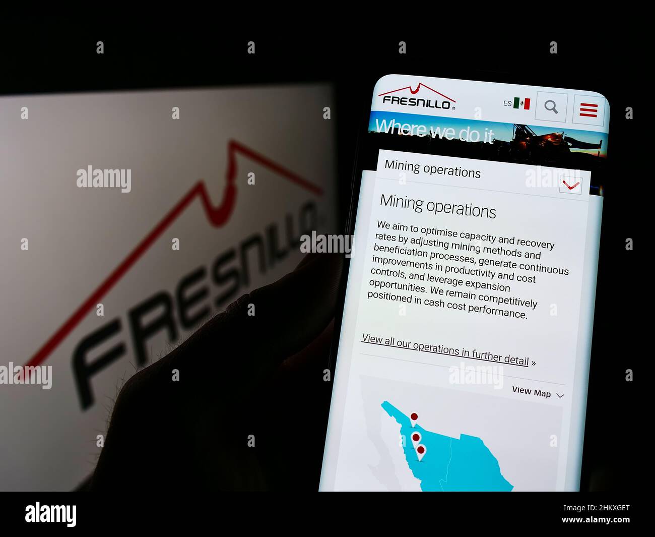 Person, die Mobiltelefon mit der Webseite des Metallbergbauunternehmens Fresnillo plc auf dem Bildschirm vor dem Logo hält. Konzentrieren Sie sich auf die Mitte des Telefondisplays. Stockfoto