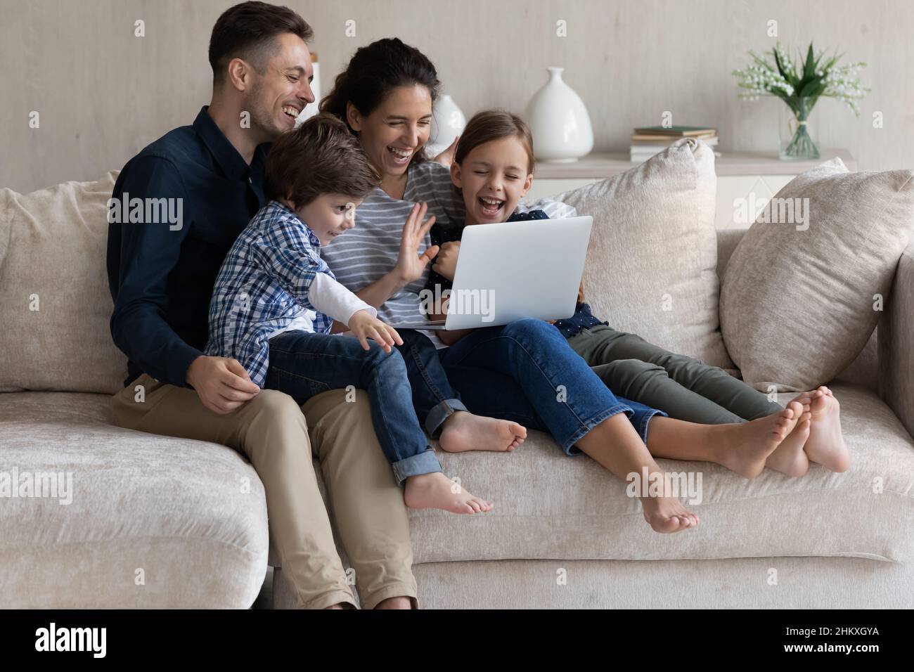 Glückliche Eltern mit zwei Kindern, die gemeinsam einen Videoanruf tätigen Stockfoto