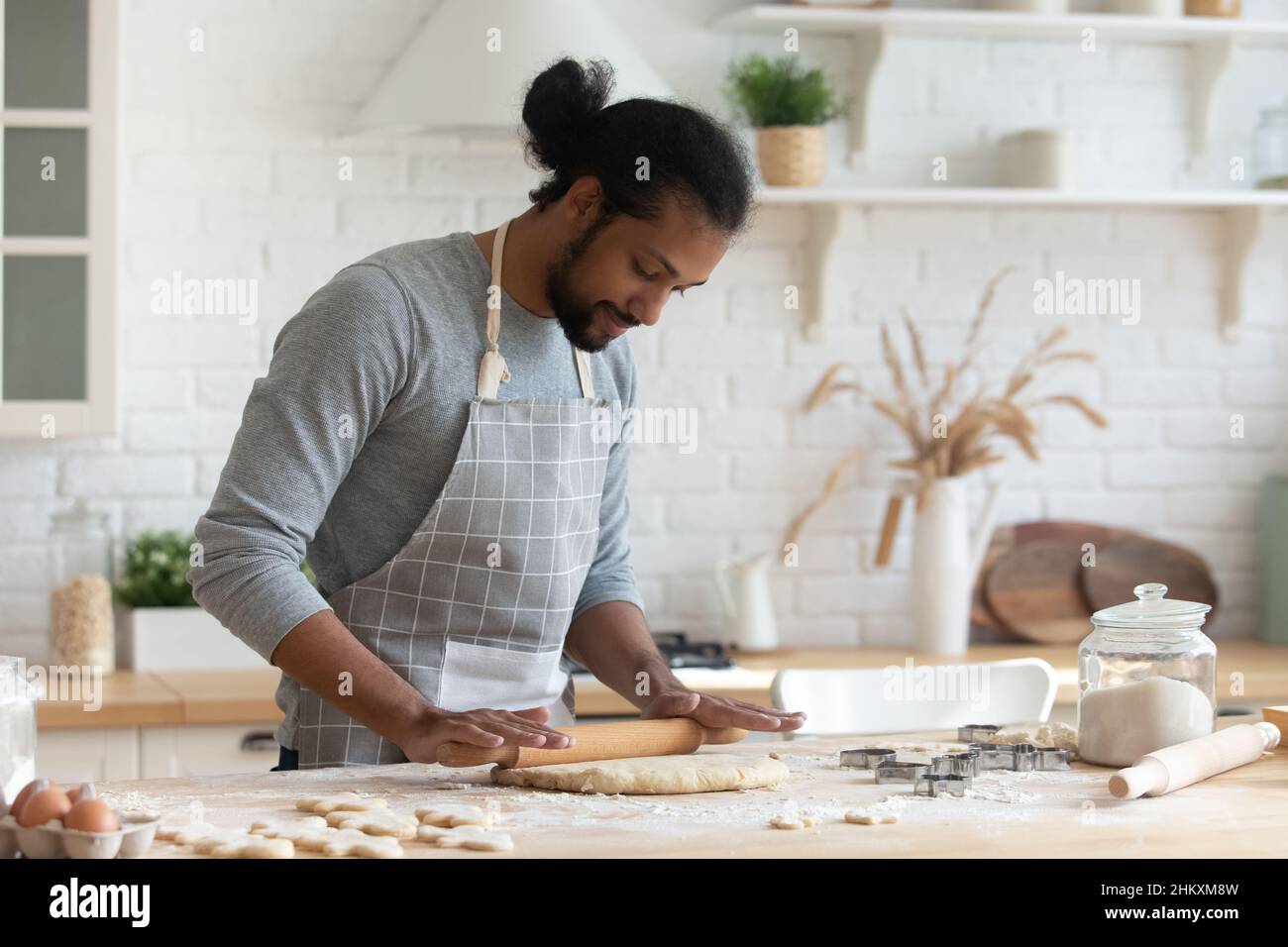 Glücklicher 30s afroamerikanischer Mann, der alleine zu Hause kocht. Stockfoto