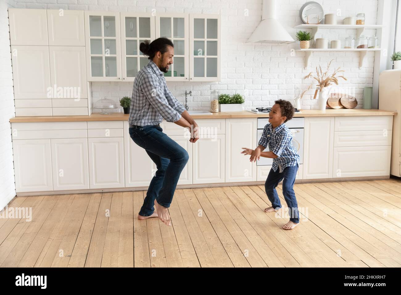 Glücklicher junger afroamerikanischer Vater, der mit einem kleinen Kind tanzt. Stockfoto