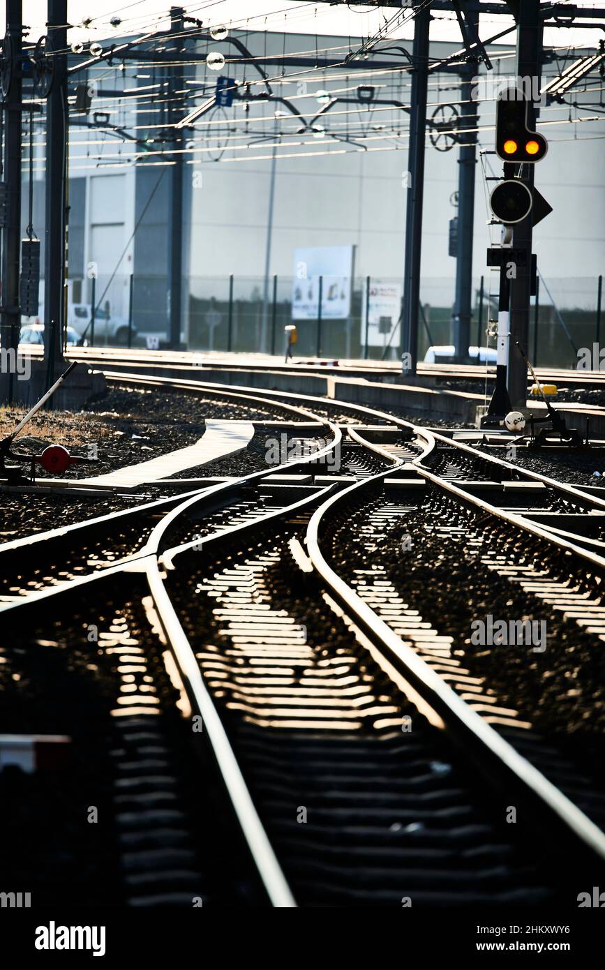 Bahnübergang und Ampel in orangefarbener Hintergrundbeleuchtung Stockfoto