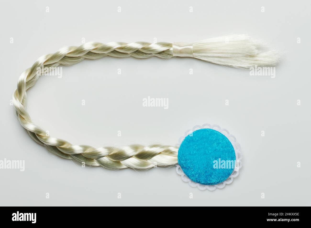 Weißer Haarzopf-Schwanz mit blauer Befestigung isoliert auf Studio-Hintergrund Stockfoto