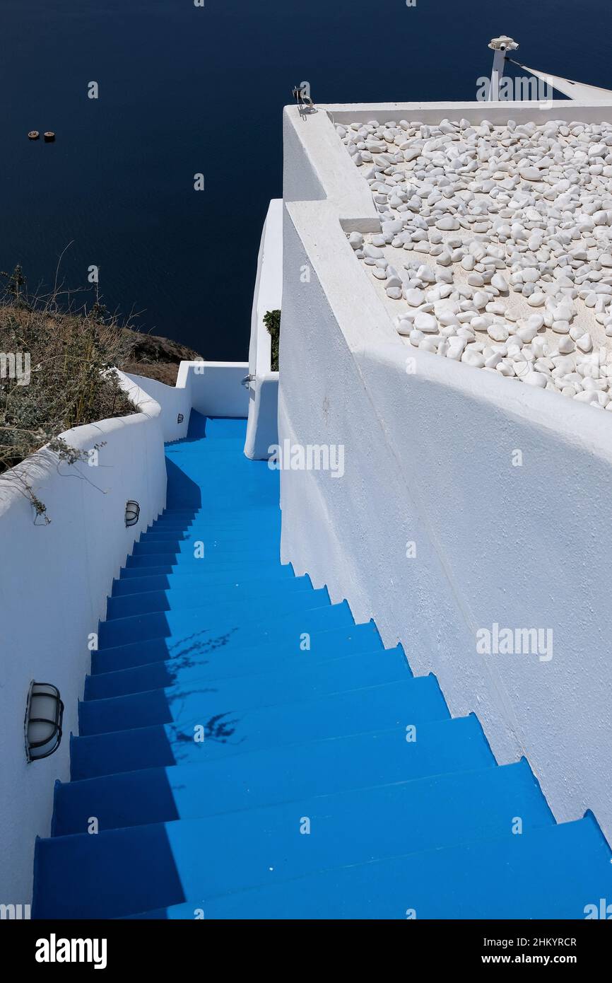 Santorini, Griechenland - 7. Mai 2021 : Blaue Treppe führt zu einem Wohngebäude mit einem wunderschönen Blick auf die Ägäis und den Vulkan Santor Stockfoto