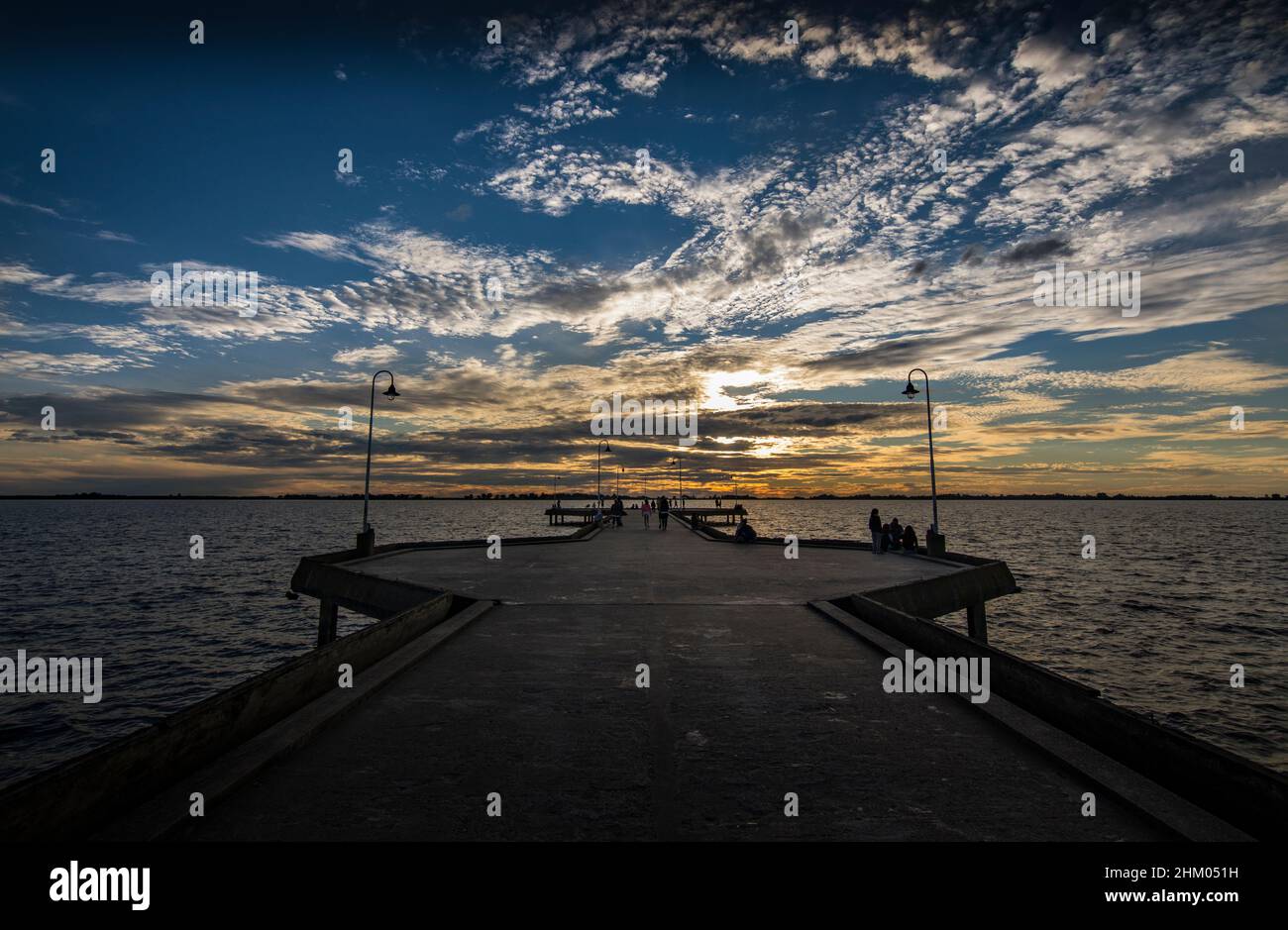 Chascomús Hauptdock mit ausdrucksstarkem Himmel bei Sonnenuntergang und Schatten, in der Lagune von Chascomús, Buenos Aires, Argentinien Stockfoto