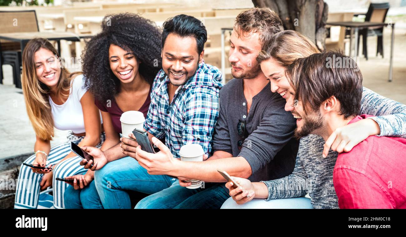 Glückliche Teenager-Freunde-Gruppe mit Smartphone mit Kaffee im Schulhof - Junge Menschen süchtig nach mobilen Smartphones - Technologie-Konzept mit einem Stockfoto