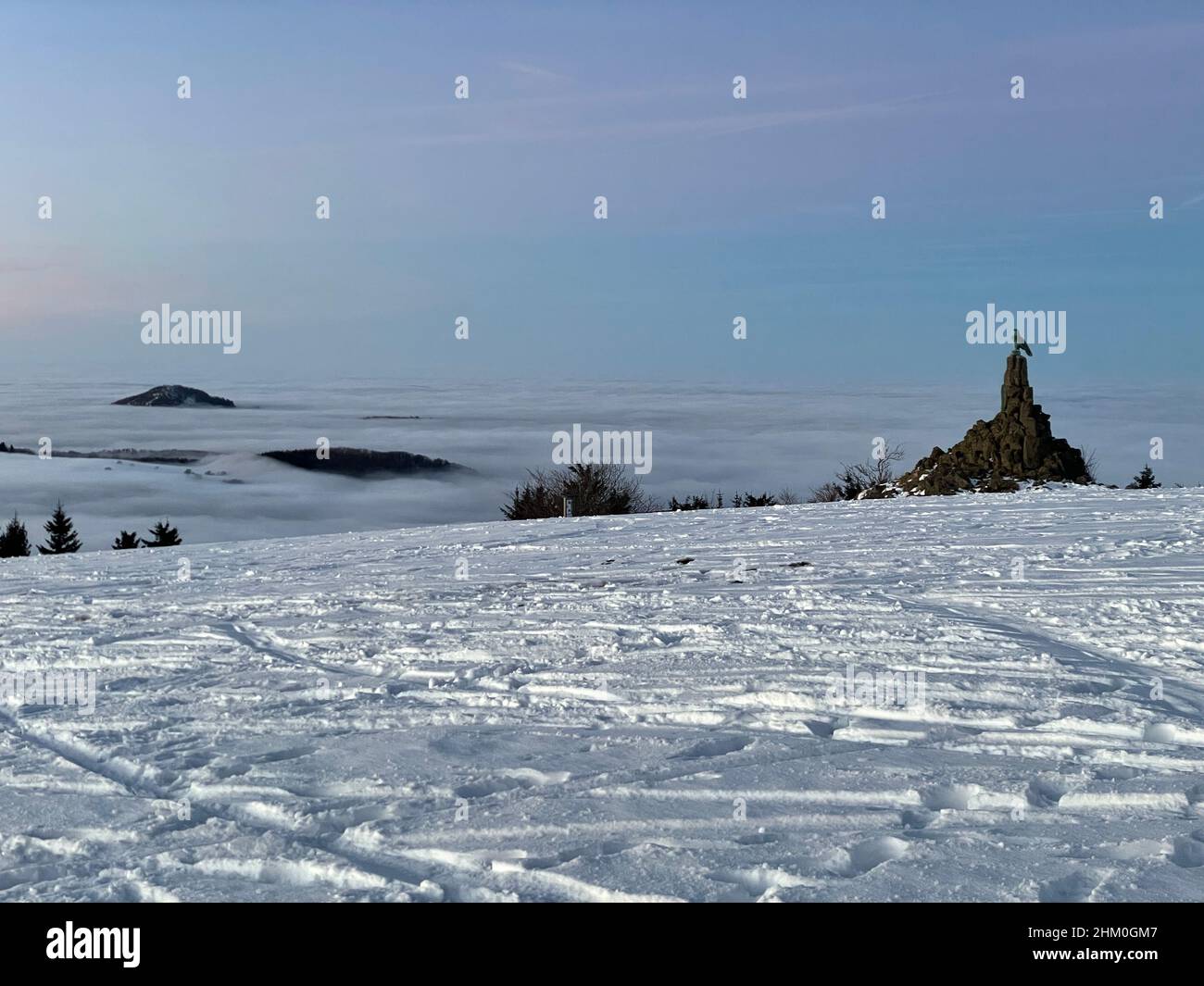 Das Konzept der Entspannung in den Bergen im Winter im Schnee auf Skiern, Snowboards oder Schlitten, Wandern unter der untergehenden Sonne bei Sonnenuntergang auf der Stockfoto