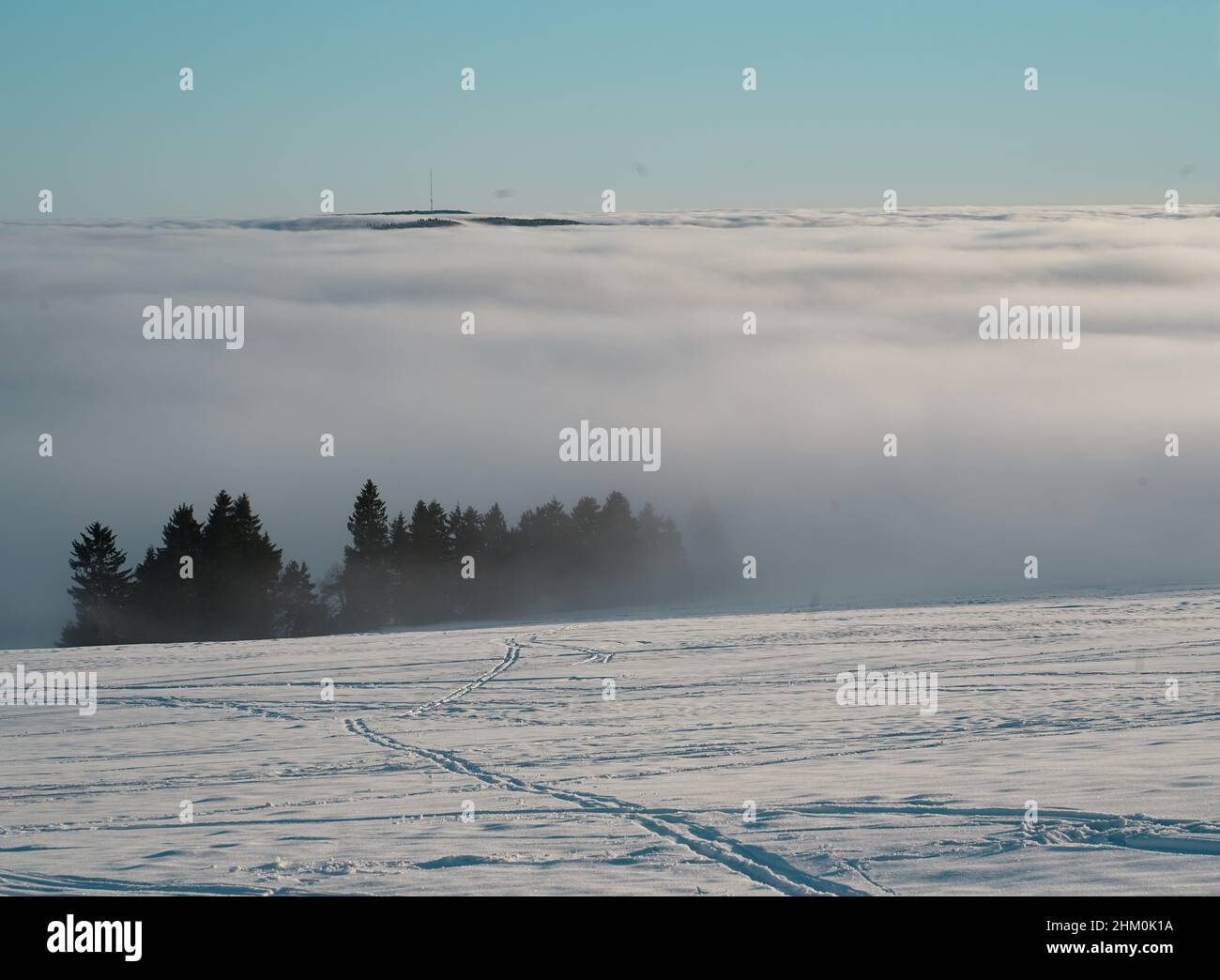 Das Konzept der Entspannung in den Bergen im Winter im Schnee auf Skiern, Snowboards oder Schlitten, Wandern unter der untergehenden Sonne bei Sonnenuntergang auf der Stockfoto