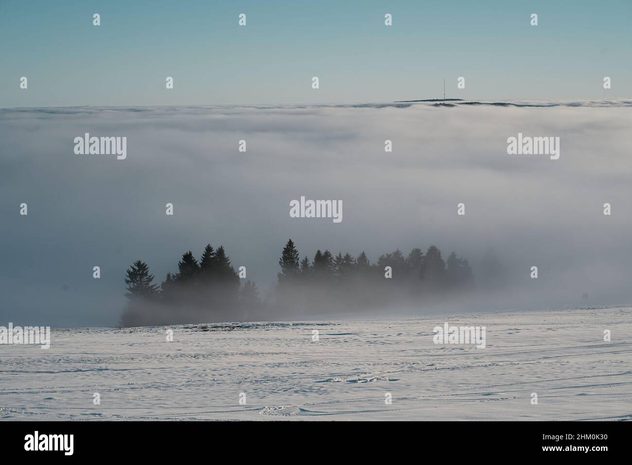 Das Konzept der Entspannung in den Bergen im Winter im Schnee auf Skiern, Snowboards oder Schlitten, Wandern unter der untergehenden Sonne bei Sonnenuntergang auf der Stockfoto