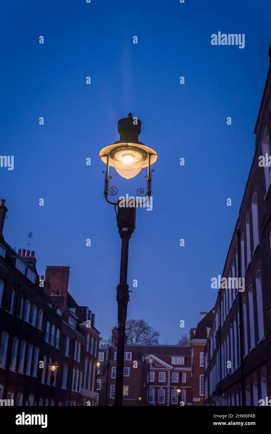 Stimmungsvolle Straße mit hoher Straßenlampe in der City of Westminster, London, England, Großbritannien Stockfoto
