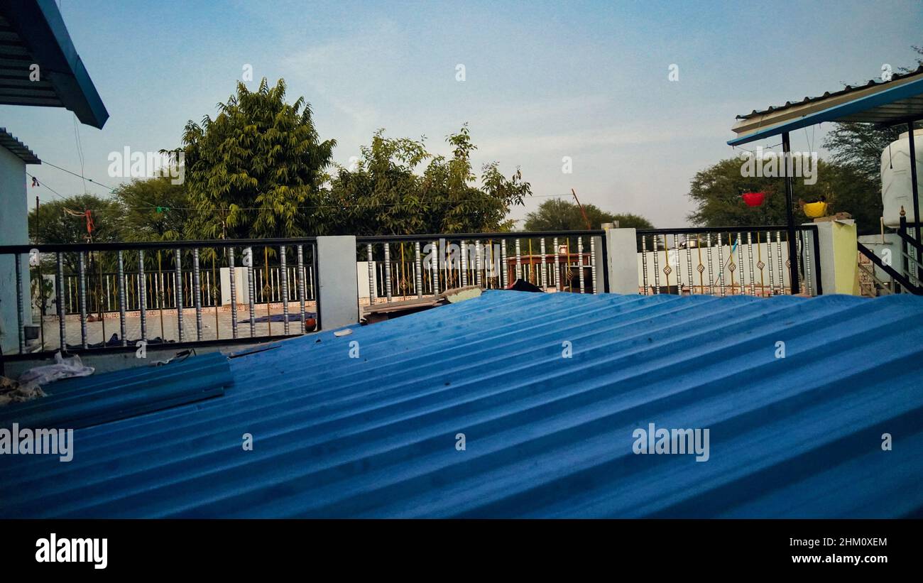 Das Dach des blauen Blechhauses. Blaues Dach auf der Terrasse eines Betonhauses, um es vor den Elementen zu schützen. Stockfoto