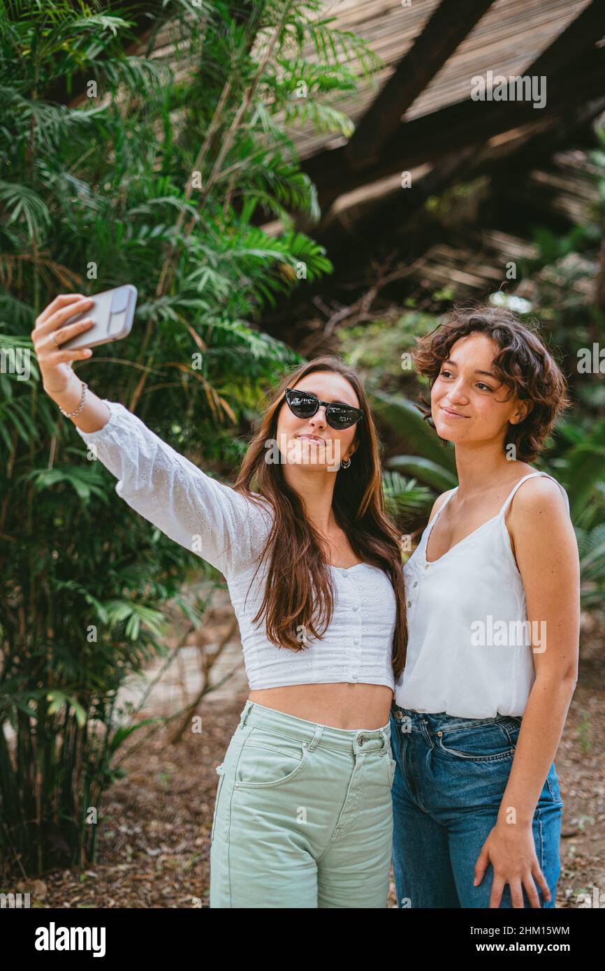 Zwei junge Teenager-Mädchen, die ein Selfie im Park machen und dabei Spaß haben. Stockfoto