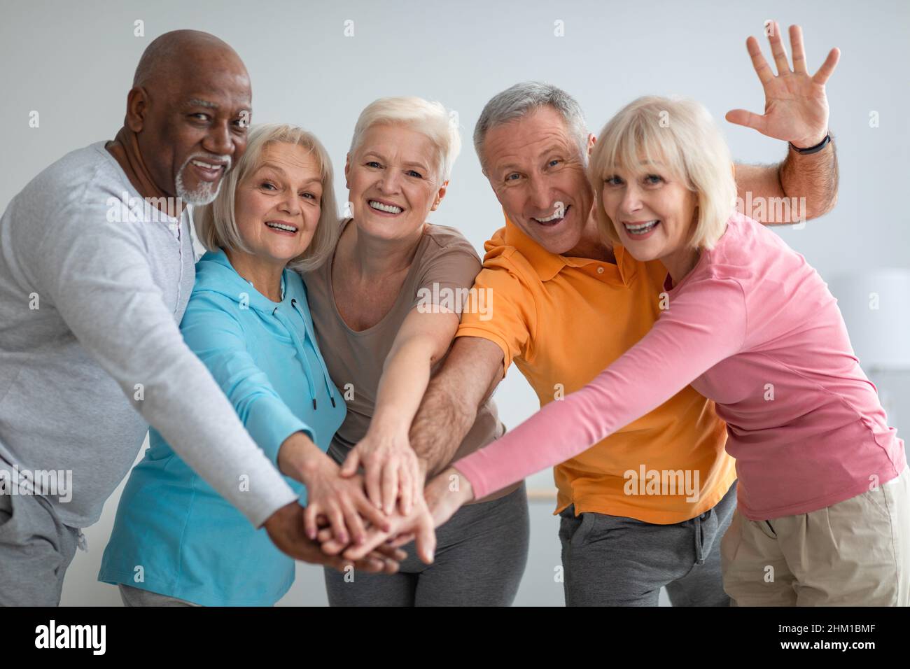 Multirassische Gruppe sportlicher älterer Menschen, die die Hände legen Stockfoto