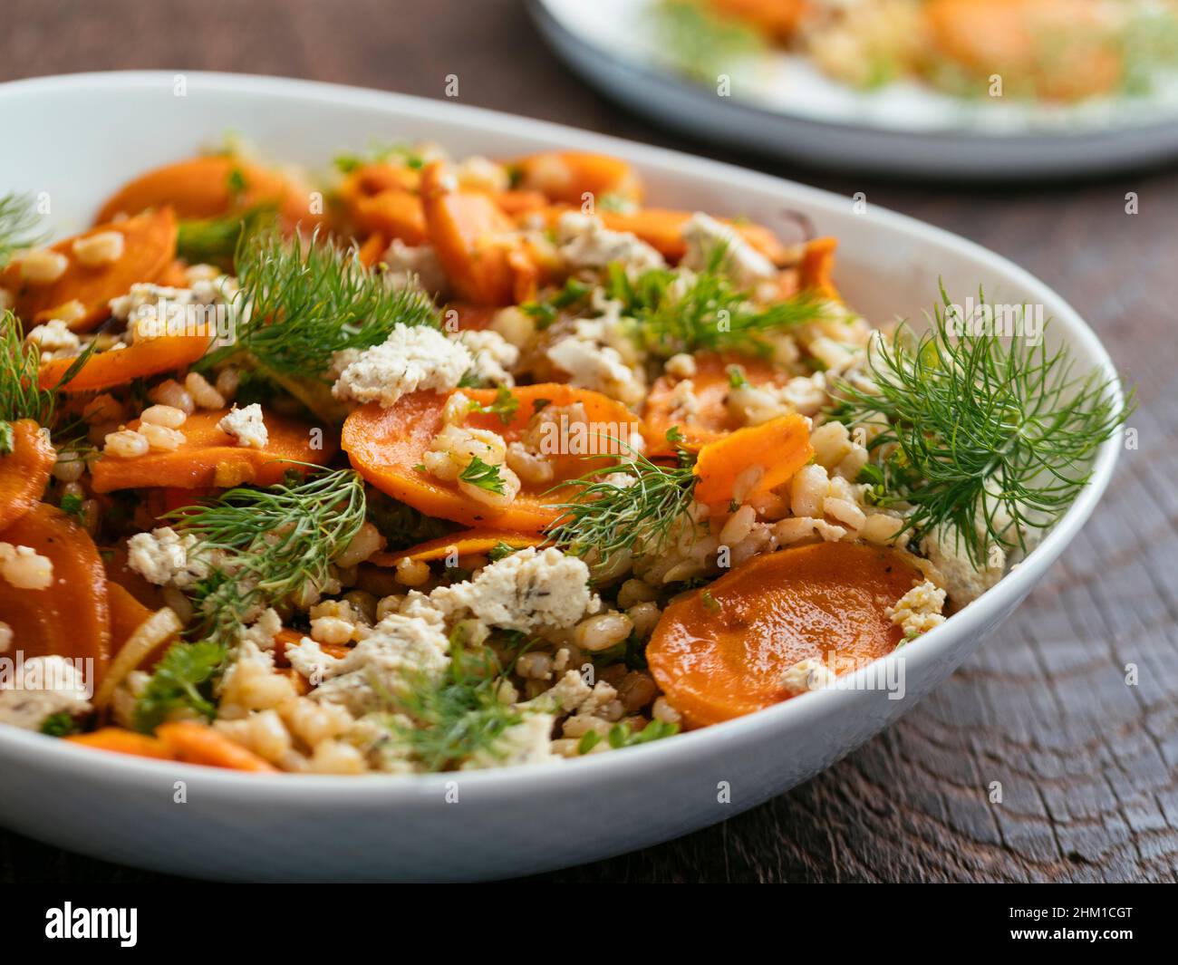 Hausgemachten gerösteten Karotten- und Gerstensalat mit veganem Feta. Stockfoto