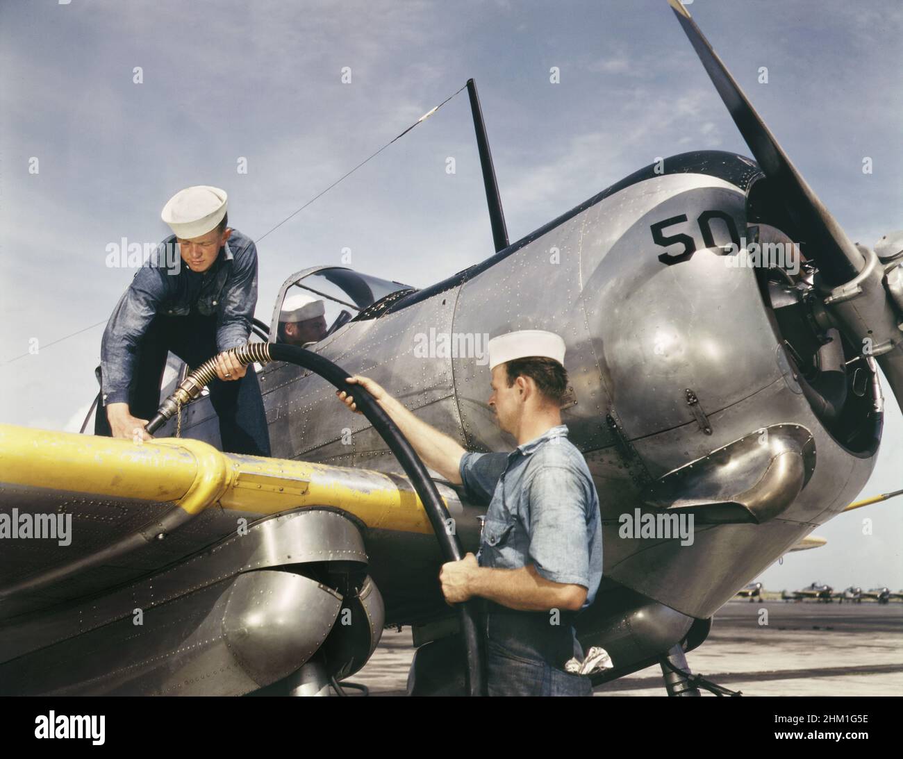 Zwei Seemannsmechaniker, Floyd Helphrey (links), W. Gardner, pumpt Benzin in das SNC-Trainingsflugzeug, Naval Air Base, Corpus Christi, Texas, USA, Howard R. Hollem, U.S. Office of war Information, August 1942 Stockfoto