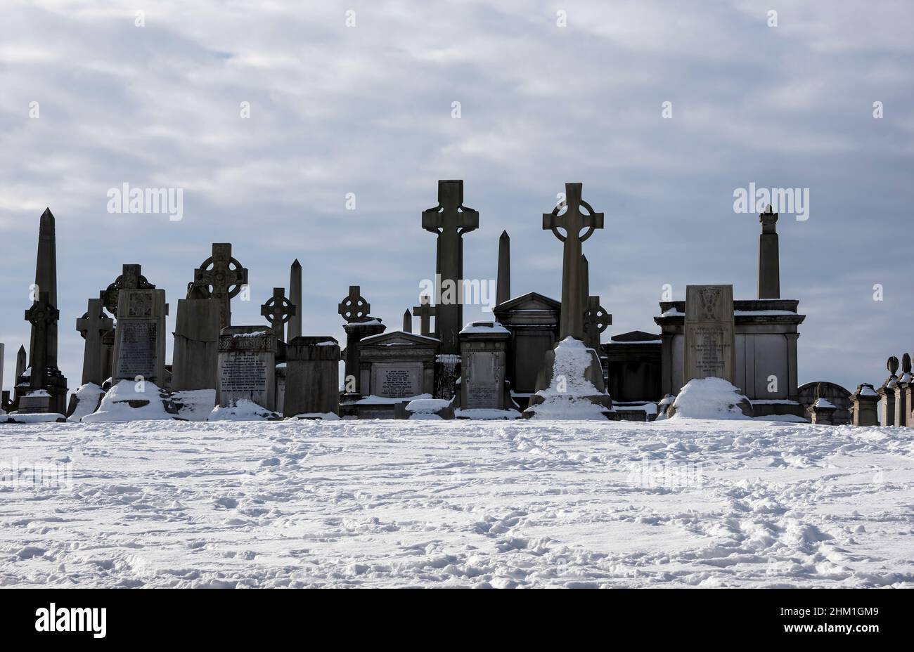 Grabsteine im Schnee bei Necropolis Cemetry, Glasgow, Schottland. Stockfoto