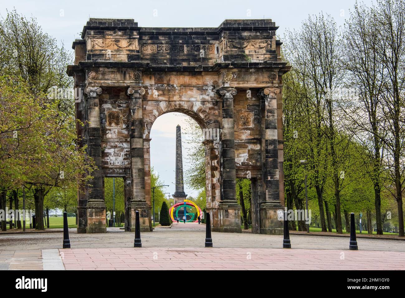 McLellan Arch Eintritt zum Glasgow Green mit der GROSSEN GCommonwealth Games-Skulptur und dem Nelson Monument, das durch den Bogen sichtbar ist. Stockfoto