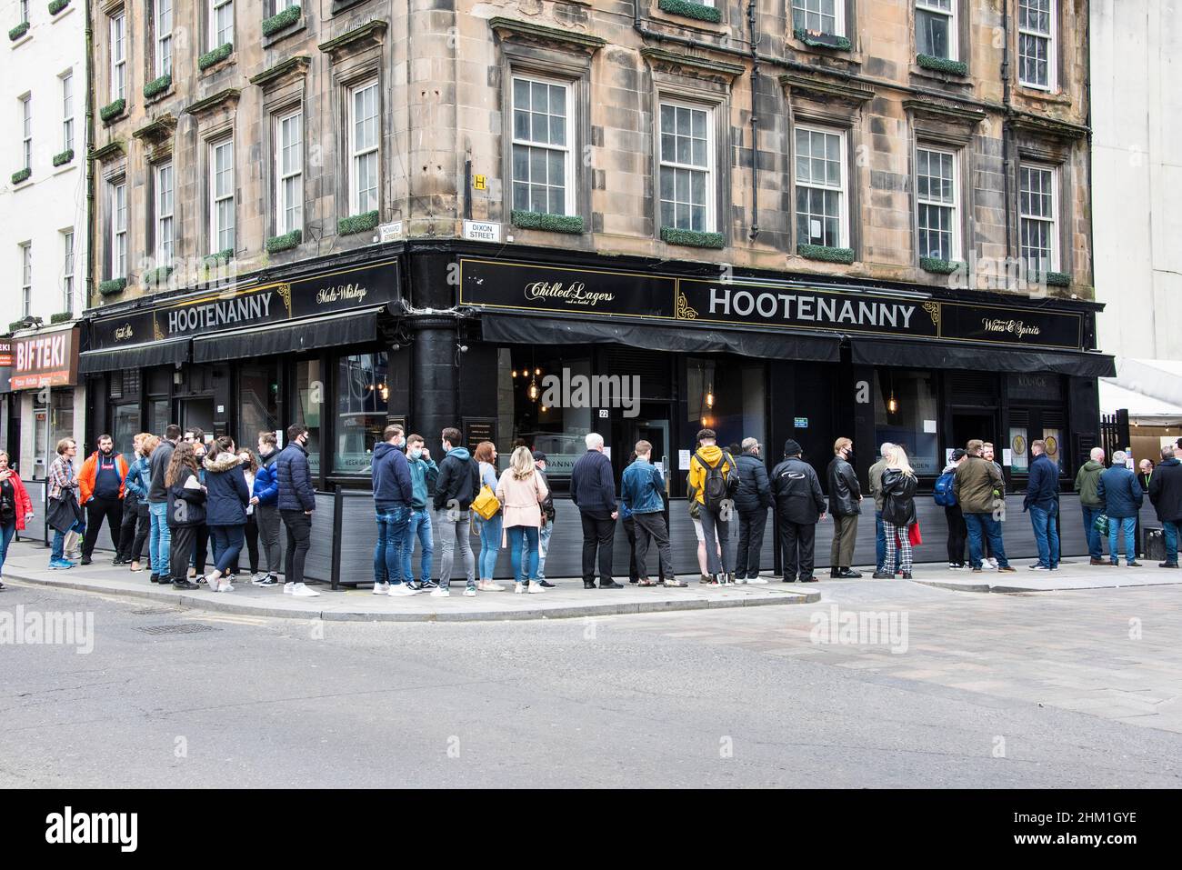 Vor dem Glasgow Hootenanny Pub können Sie sich nach den Lockdown-Regeln von Covid anstellen. Stockfoto